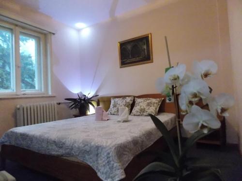 VladayaBoeritza Hotel Complex的一间卧室配有白色床单和鲜花。
