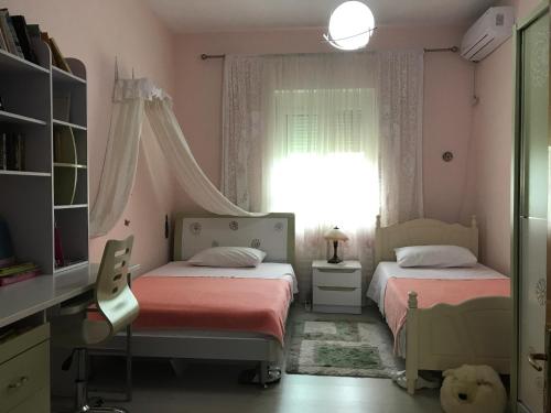 地拉那Guesthouse Hygge的配有粉红色墙壁和窗户的客房内的两张床