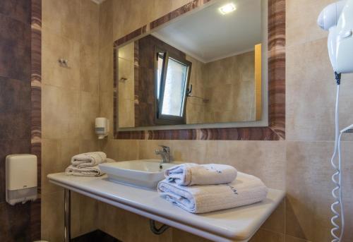 卡法斯爱琴海之梦酒店的浴室配有盥洗盆、镜子和毛巾