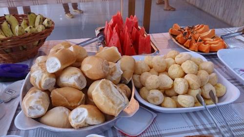 特林达迪Pousada Santana - Trindade Goiás的一张桌子,上面放有面包和蔬菜盘