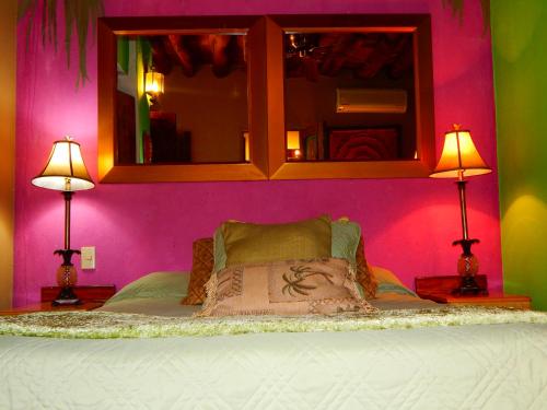 埃尔富埃尔特Hotel Torres Del Fuerte的一间卧室配有一张粉色墙壁和两盏灯。
