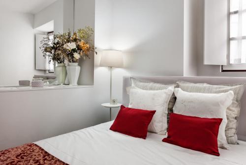 埃武拉Casa Becco dos Assucares, com free garagem - Centro Histórico的卧室配有带红色枕头的白色床