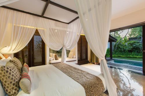 塞米亚克巴厘岛水别墅精品度假Spa酒店的一间卧室设有一张床和一个游泳池