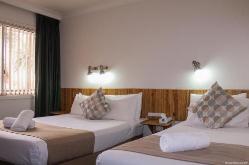 Leeton里弗赖纳汽车旅馆的酒店客房设有两张床和窗户。