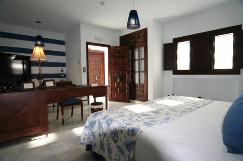 圣玛丽亚港圣巴托洛梅皇宫酒店的一间卧室配有一张床、一张桌子和一台电脑
