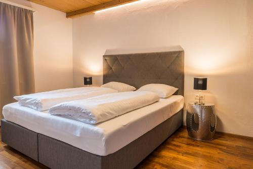 乌登斯Sportchalet Zillertal的卧室内的一张大床,配有两盏灯