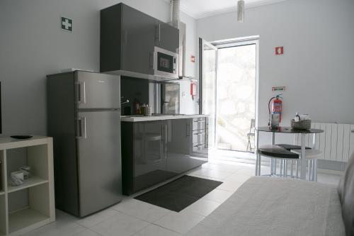 波尔图Covelo Apartment的厨房配有冰箱、桌子和窗户。