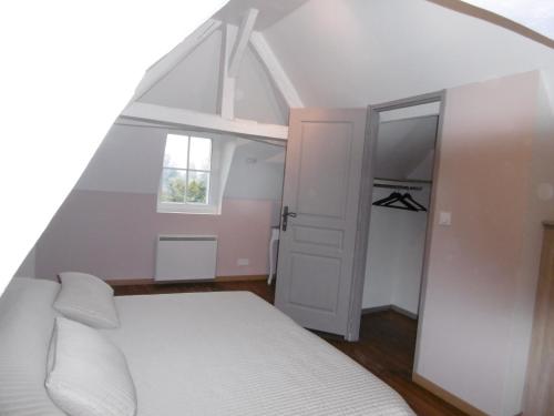 希农Le petit domaine des Aubuis的卧室配有白色的床和窗户。