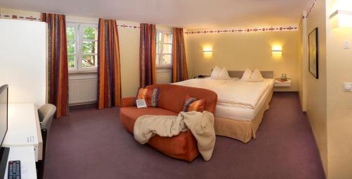 拜罗伊特鲁目勒餐厅酒店的配有一张床和一把椅子的酒店客房