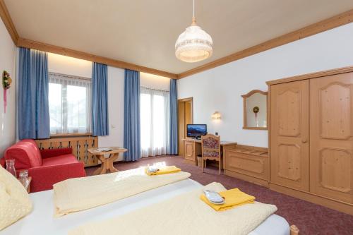 瓦尔道拉戴里维特酒店的一间卧室配有一张大床和一张红色椅子