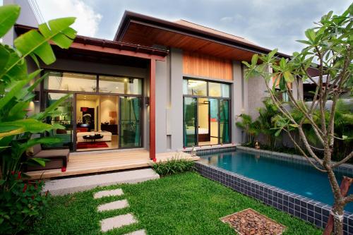奈汉海滩Two Villas HOLIDAY - Onyx Style Nai Harn Beach, Phuket的一座房子前面设有游泳池
