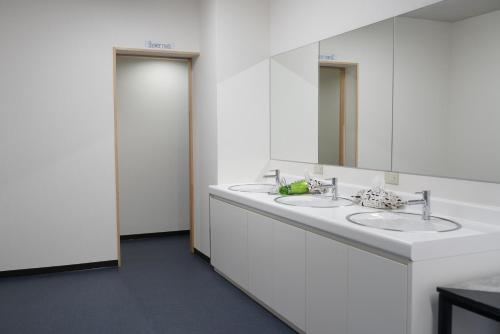 大阪住吉旅馆的白色的浴室设有两个盥洗盆和镜子