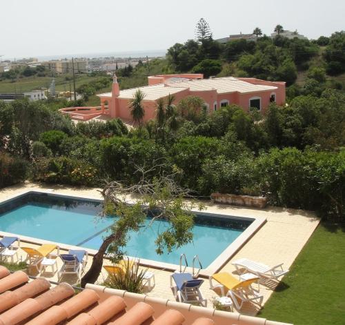 拉戈斯Falfeira Apartments的一个带椅子的游泳池以及一座房子