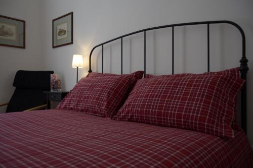 罗马圣彼得大教堂伊尔利莫度假屋的一张带红色床单和枕头的床