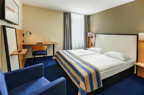 策勒策勒城际酒店的配有一张床和一把椅子的酒店客房