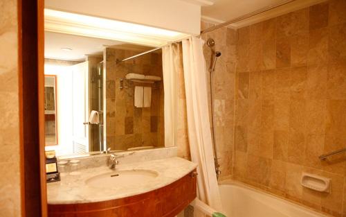 Tuban图班特罗皮斯酒店的一间带水槽、浴缸和镜子的浴室