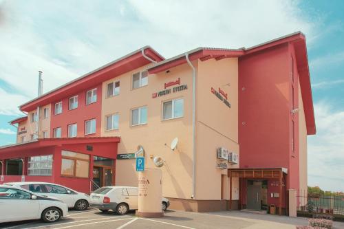 布拉迪斯拉发维茨达酒店的一座红色的建筑,汽车停在停车场