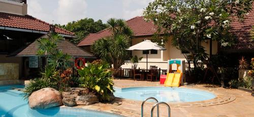 Tuban图班特罗皮斯酒店的一座房子旁边的游泳池,带滑梯