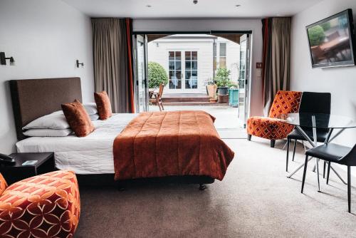 基督城格兰奇汽车旅馆的酒店客房带一张床、一张桌子和椅子