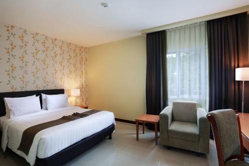 茂物IPB Convention Hotel Botani Square的配有一张床和一把椅子的酒店客房
