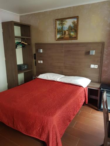 巴黎贝尔塔酒店的一间卧室配有一张带红色毯子的大床