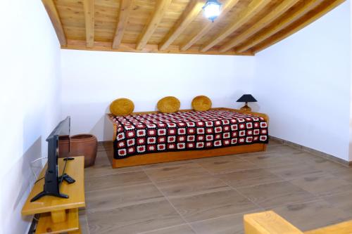 Alto do SulQuinta do Fragoso的一间卧室配有一张床、一台电视和一张桌子