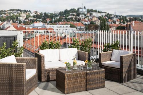 布拉迪斯拉发布拉迪斯拉发法肯斯特纳尔酒店的阳台设有藤椅和一张桌子,享有美景。