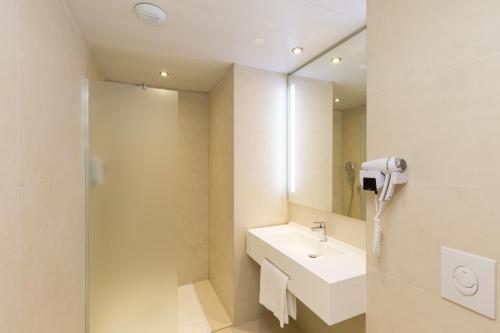 隆维B&B HOTEL Longwy Porte du Luxembourg的一间带水槽和镜子的浴室