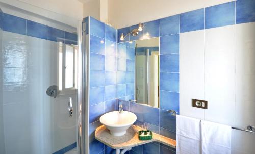 卡波利韦里斯特拉马里斯酒店的蓝色瓷砖浴室设有水槽和镜子