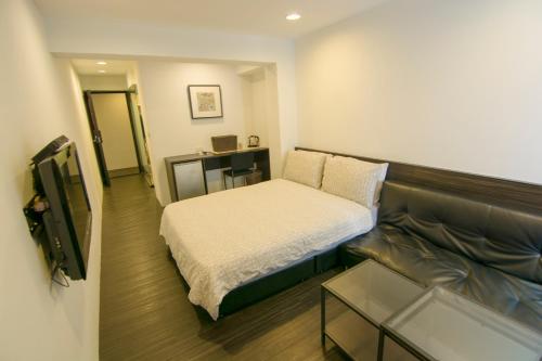 台北忠孝敦化民宿的小房间设有床和沙发
