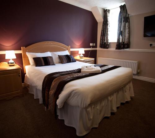 盖茨黑德天使观景酒店的一间卧室配有一张大床和两盏灯。