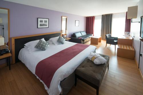 蒙彼利埃蒙彼利埃安提戈涅中心美居酒店的酒店客房设有一张大床和一间客厅。
