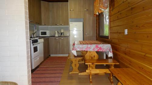 Juankoski泰尤图威特山林小屋的一间带桌子和冰箱的小厨房