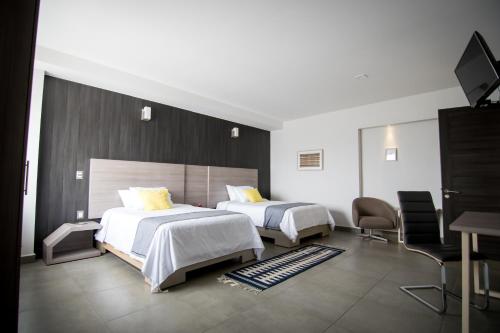 瓦哈卡市Maria Ines Hotel Suite的酒店客房设有两张床和电视。