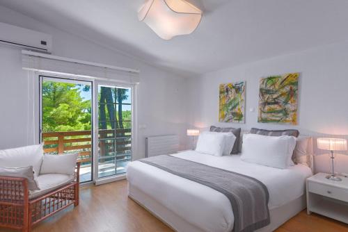 撒尼海滩撒尼白色别墅的卧室配有一张白色大床和一把椅子