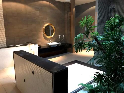淡水富悦旅馆的浴室设有水槽、镜子和植物