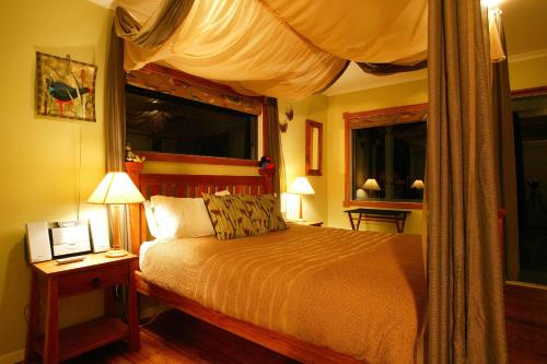 怀托摩洞穴艾布赛尔宾馆的一间卧室配有一张带天蓬的床和两个窗户。
