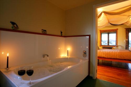 怀托摩洞穴艾布赛尔宾馆的浴缸、两杯酒和床
