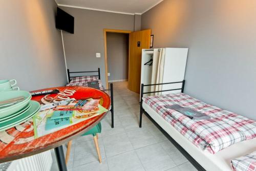 扎雷miniHostel Żary的客房设有两张床、一张桌子和一台冰箱