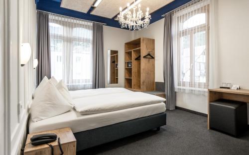 达沃斯Hotel Ochsen by Mountain Hotels的卧室配有一张床、一张书桌和窗户。