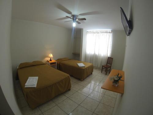 纳斯卡Hospedaje el Telar的客房设有两张床和吊扇。