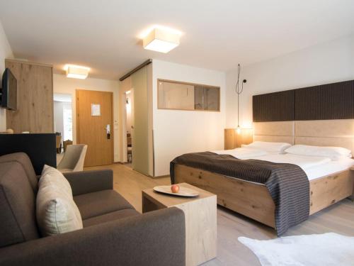 布兰德微拉阿凯提度假酒店的一间卧室配有一张床,客厅配有沙发