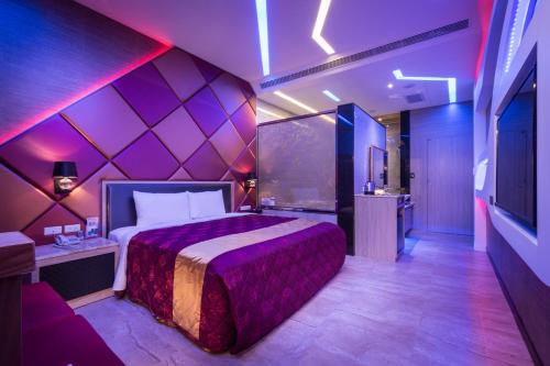 Jiuru欧阁汽车旅馆 - 屏东馆的一间卧室配有一张紫色墙壁的床