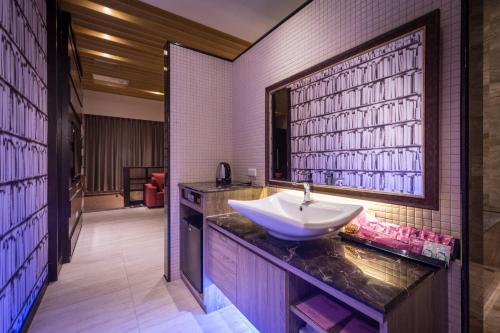 Jiuru欧阁汽车旅馆 - 屏东馆的一个带镜子的柜台上水槽的浴室