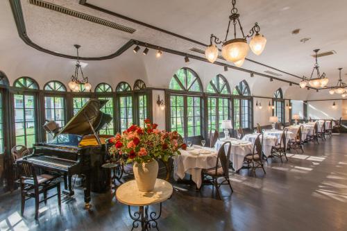 白马村特劳米雷餐厅酒店的一间带桌子和钢琴的用餐室