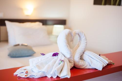 蒂锡利维奥迈尔酒店的两条毛巾,形状像天鹅,坐在床上
