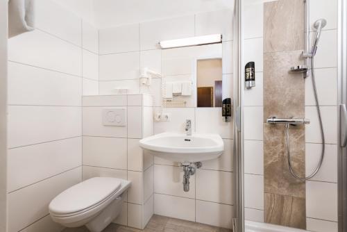 格拉茨玛丽亚希尔费酒店的白色的浴室设有卫生间和水槽。
