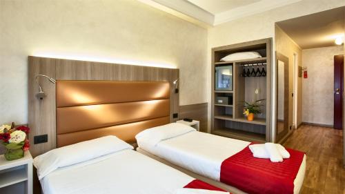 米兰伽玛酒店的酒店客房设有两张床和一个衣柜。