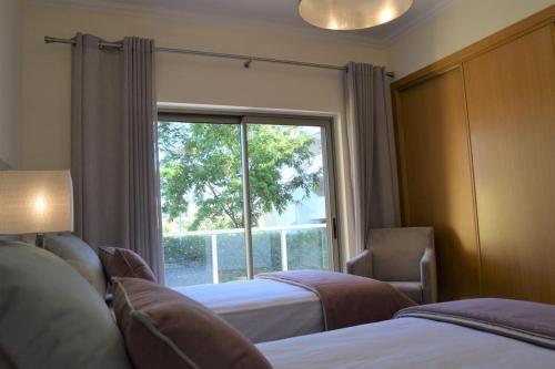 阿尔布费拉Albufeira Marina Gold的一间卧室设有两张床和大窗户