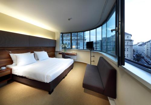 维也纳欧洲之星使馆酒店的一间卧室设有一张床和一个大窗户